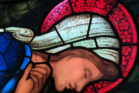 Close-up from the Nativity window of Mary in adoration of baby Jesus.